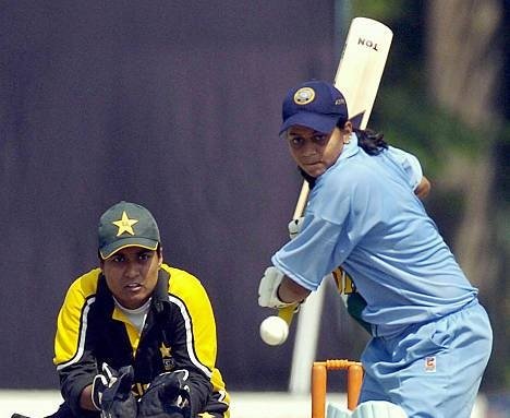 LAHORE, PAKISTAN: Indian under-21 women cricket team captain Karuna Jain Venkatachar (R) hits a boundery as Pakistani wicket-keeper Amran Khan looks on in the second one-day match at Bagh-e-Jinnah stadium in Lahore, 29 September 2005. India won the second match against Pakistan by 30 runs. AFP PHOTO/Arif ALI (Photo credit should read ARIF ALI/AFP via Getty Images)