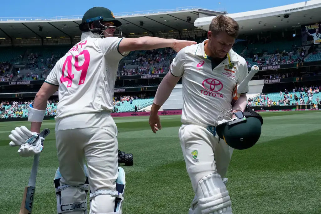 David Warner receiveing a pat on the back from Steve Smith